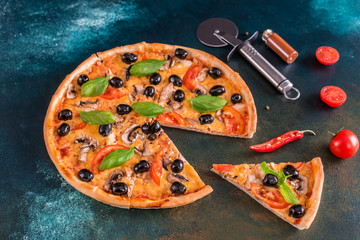 Tasty fresh hot pizza against a dark background. Pizza, food, vegetable, mushrooms.  It can be used as a background