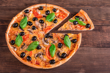 Tasty fresh hot pizza against a dark background. Pizza, food, vegetable, mushrooms.  It can be used as a background