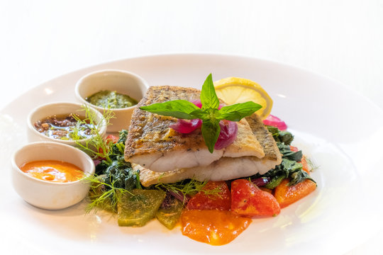 close up of pan seared grilled sea bass snapper fillet with healthy vegetables