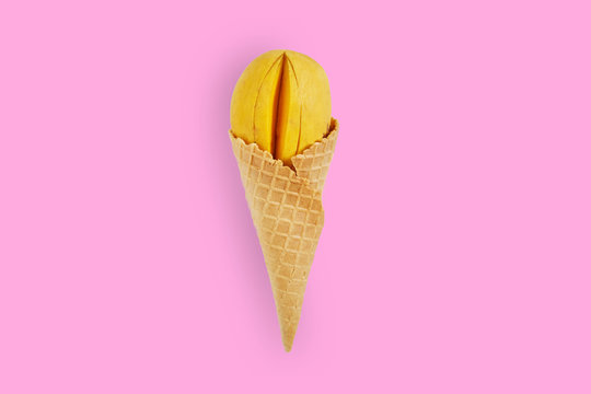 Creative ideas yellow mango ice cream on pastel pink background. Minimal food concept. Flat lay. Top view.