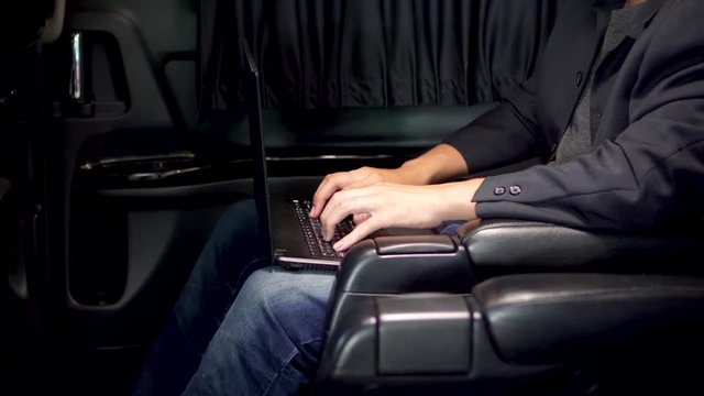 Smart young businessman using laptop and mobile in luxury automobile, working ,