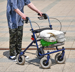 Fototapeta na wymiar Old woman walks with a wheeled walker