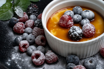 Creme Brulee mit Beeren und Zucker überstreut