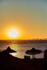 Beautiful beach with deck chairs and parasol at dawn.Silhouette of the beach, a resting place on the beach during sunset