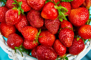Ripe red strawberries on blue table, Strawberries in white basket. Fresh strawberries. Beautiful strawberries. Diet food. Healthy, vegan. Top view. Flat lay.