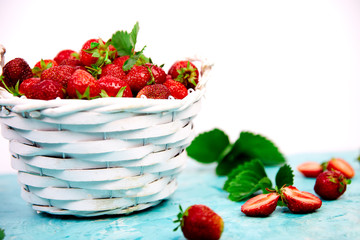 Ripe red strawberries on blue table, Strawberries in white basket. Fresh strawberries. Beautiful strawberries. Diet food. Healthy, vegan. Copy space.