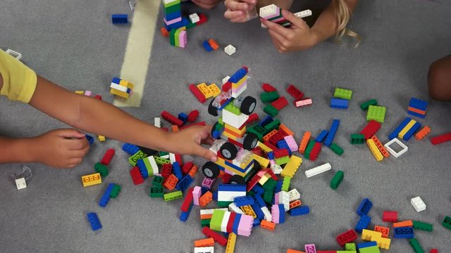 Kids playing with colorful constructor on the floor. Leisure and cognitive development of preschool kids.