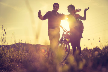 Sundown scenery with young couple: Boy and girl are doing a gesture