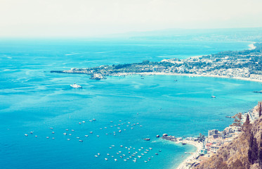 Obraz na płótnie Canvas Beautiful seacoast of Sicily, sea view with sailboats, motor boats from Taormina, Italy .