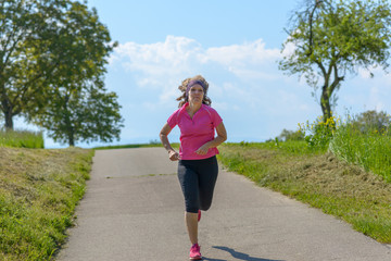 Sporty woman jogging along a country road