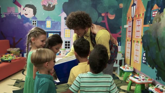Kids having fun on Birthday party. Happy kids with animator in playroom. Children activities concept.