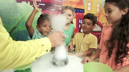 Science show for kids. Happy children doing chemical experiments in playroom. Birthday party entertainment.