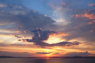 Beautiful cloudy sunset and sea landscape. Pink and gold colored sky in the evening.
