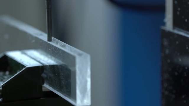 CNC milling machine processes plexiglass plastic part