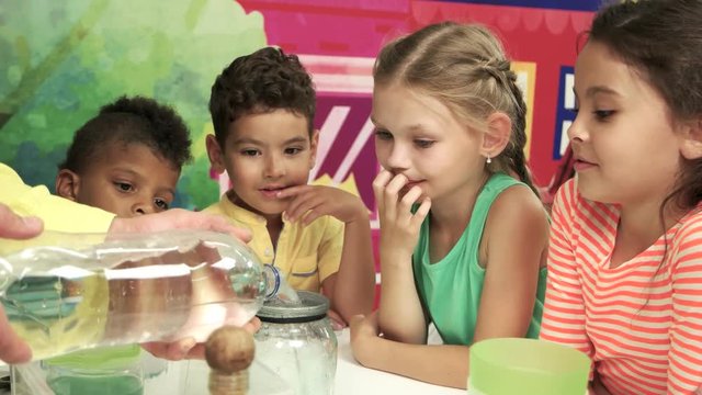 Group of happy kids watching experiment. Smiling faces of happy children. Science party for kids.