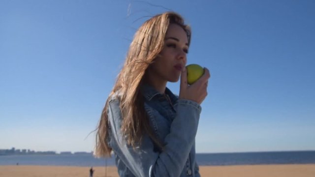 the beautiful girl eating Apple outdoors healthy food