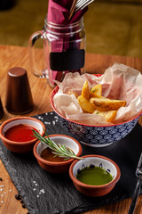 The concept of Mexican cuisine. Baked spicy potatoes with pepper, with different sauces, salsa, guacamole, chilli and shrimp. Background image. copy space