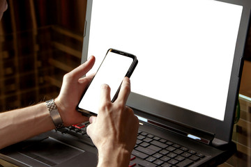 Man working on his laptop with mobile phone