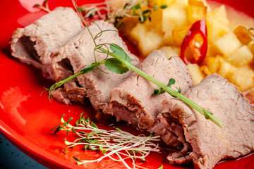 French cuisine concept. Baked duck fillet in beer, with pear and hot red pepper. Micro green peas. European serving dishes in the restaurant. copy space