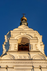 Closeup of the bell tower of the Holy Trinity Stephan monastery. The setting sun emphasizes the decoration of the building. The bells of the belfry are visible.