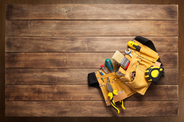 Fototapeta premium instruments in tool belt at wooden table