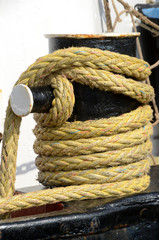 Fototapeta na wymiar Heavy mooring rope wound around a bollard