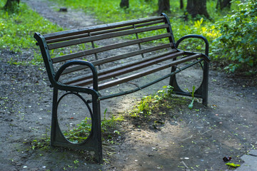 Broken wooden bench with metal frame in the park