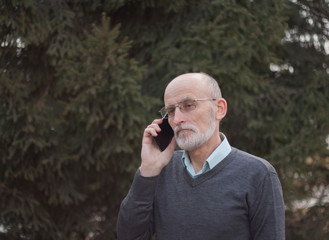 Elderly male white beard talking on a mobile phone