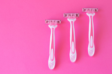 Three female razors pink color on an a pink background. Razor for personal hygiene for hair removal
