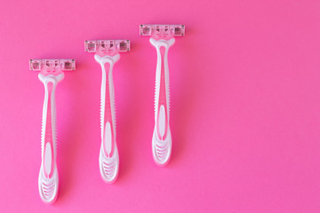 Three female razors pink color on an a pink background. Razor for personal hygiene for hair removal
