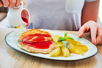 woman eating pancakes with apples