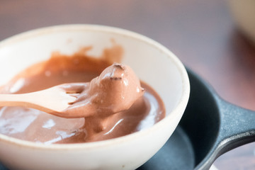 Chocolate ice cream in a melting process in bowl