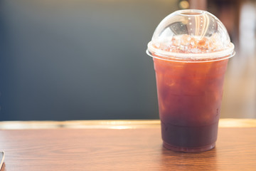 Ice of americano on wood table in coffee shop