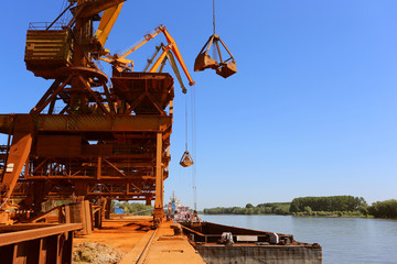Fototapeta na wymiar Industrial cargo port with operating cranes on the Danube river
