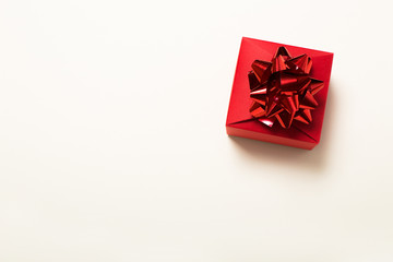 beautiful gift boxes wrapped in paper with a red ribbon and a bow on a beige surface. Top view with copy space.