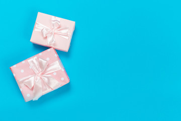 beautiful gift boxes wrapped in paper with gold and pink ribbon on a blue surface. Top view