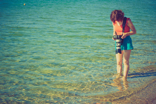 Woman during vacations taking picture of sea water