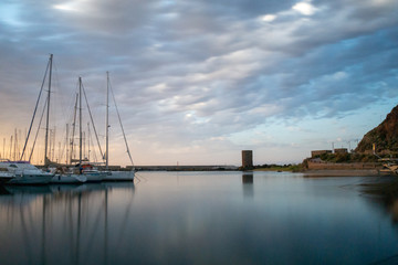 Fototapeta na wymiar harbor near of castelsardo sardinia italy. long shuttertime. sunset with boats and landmarks