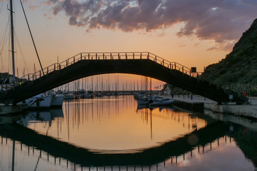 bridge over water. castelsardo sardinia italy harbour. sunset reflection
