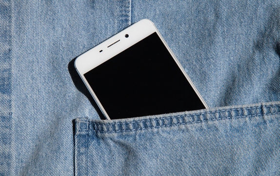 white phone in the pocket of a denim jacket - Powered by Adobe