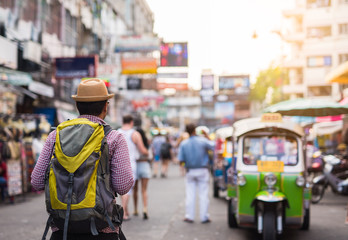 Young asian traveller man walking in Khaosan Road walking street in bangkok thailand on vacation...