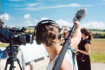 Foto auf Alu-Dibond Woman holding microphone on a boom during video production © Kzenon
