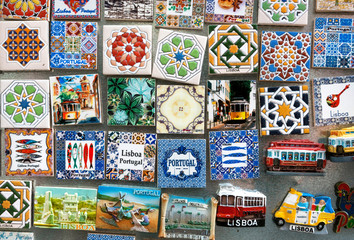Patterns and symbols of portuguese cities on souvenir magnets of street market of Portugal.