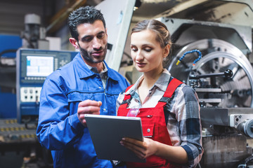 Woman and man manufacturing worker in discussion 