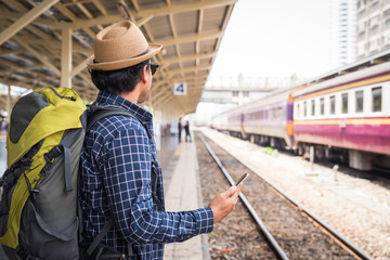 Fototapeta premium Young traveler man at platform train station. Traveling concept.