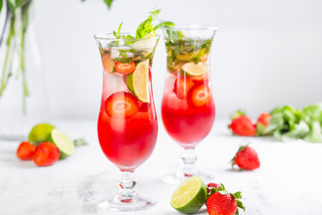 Pink lemonade with strawberries, lime, basil and mint