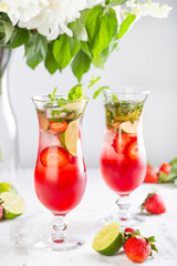Pink lemonade with strawberries, lime, basil and mint