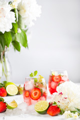 Pink lemonade with strawberries, lime, basil and mint
