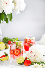 Pink lemonade with strawberries, lime, basil and mint