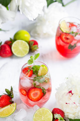 Pink lemonade with strawberries, lime, basil and mint